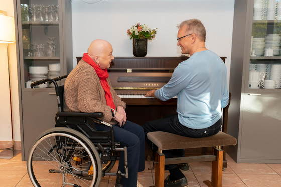 Ehrenamtlicher am Klavier mit einem Gast - Diakonie Hospiz Wannsee