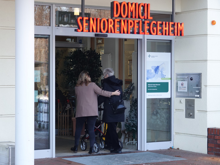 Mandy Schneider aus der Hospizverwaltung begleitet eine Gästin zu Fuß zurück in das Gebäude Mandy Schneider aus der Hospizverwaltung begleitet eine Gästin zu Fuß zurück in das Gebäude