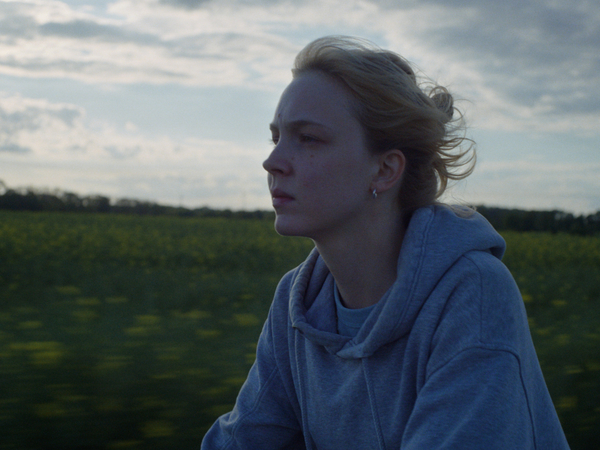 Filmausschnitt aus dem Kinofilm "Sechswochenamt" mit einer Frau vor einem mit Gras bewachsenen Hügel und einem Himmel mit Wolken. Filmausschnitt aus dem Kinofilm "Sechswochenamt" mit einer Frau vor einem mit Gras bewachsenen Hügel und einem Himmel mit Wolken.